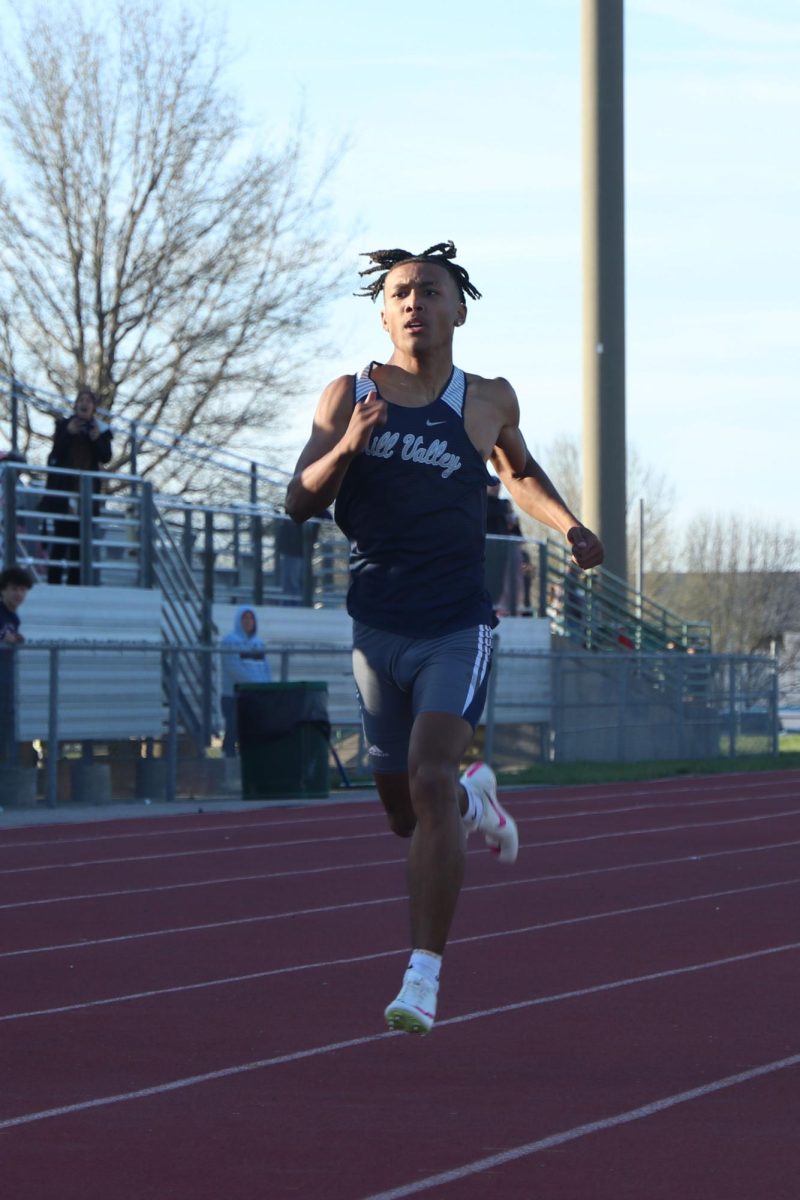 Focusing on the finish line, junior Desmon Williams pumps his arms to gain speed.