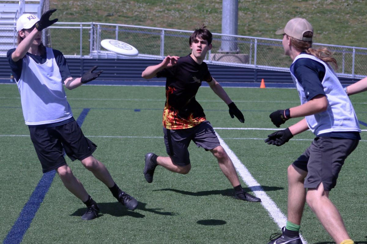 Senior Georgia Hansen prepares to catch the frisbee thrown by sophomore Will Schieber during the teams final game. “At this point in the game we were pretty far down against Shawnee Mission Northwest, Hansen said. “We were expecting that we would be doing a lot better so we had to switch up our strategy and decided to go for shorter passes.”