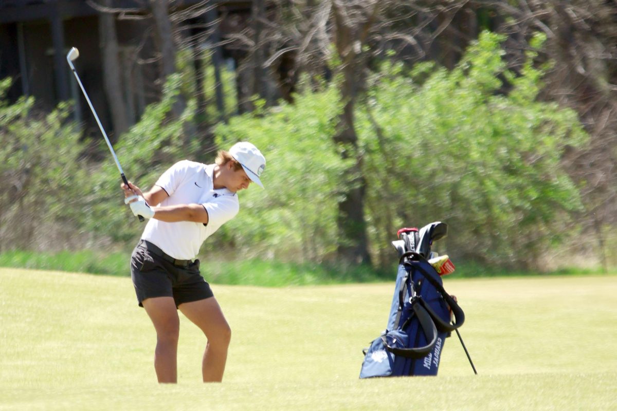 Beginning his swing, junior Jackson Sprecker focuses on the ball.