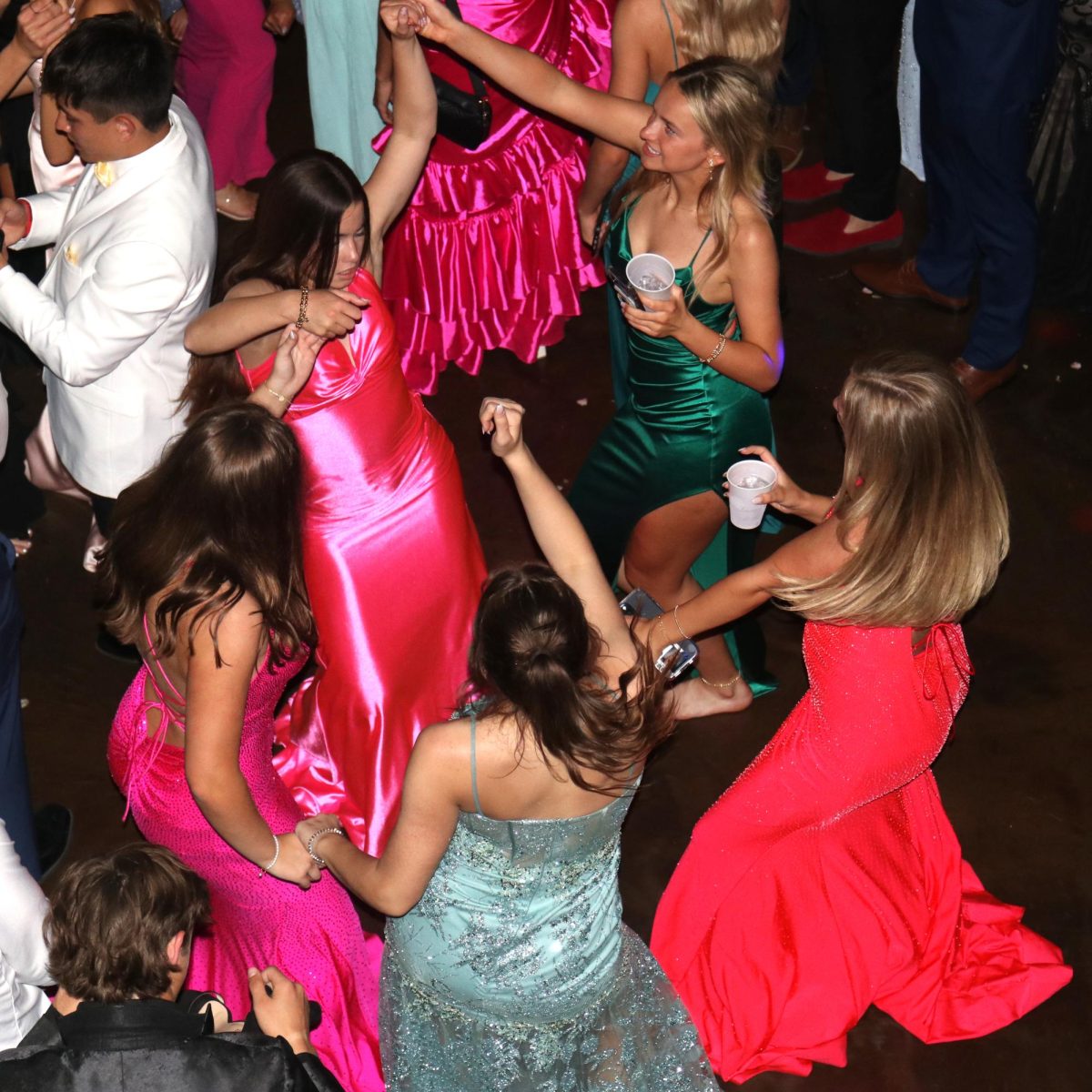 Holding hands, juniors Lauren Welch and Marissa Hoelting dance to the music together with their friends.