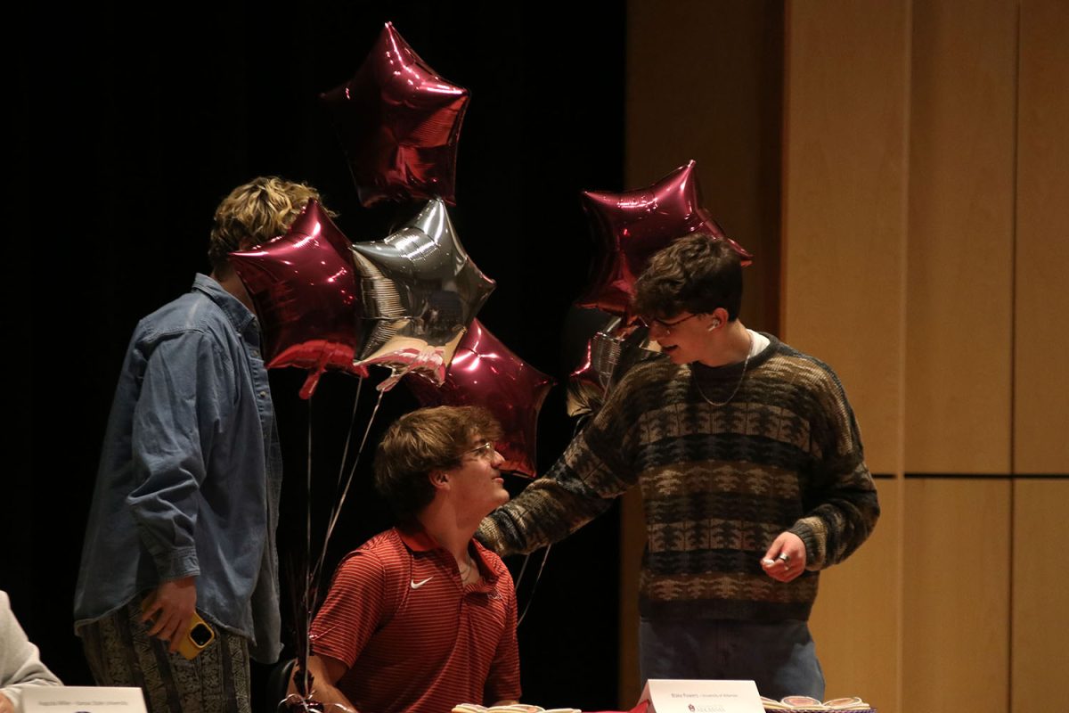 After signing to the University of Arkansas, senior Blake Powers shares a moment with his friends.

