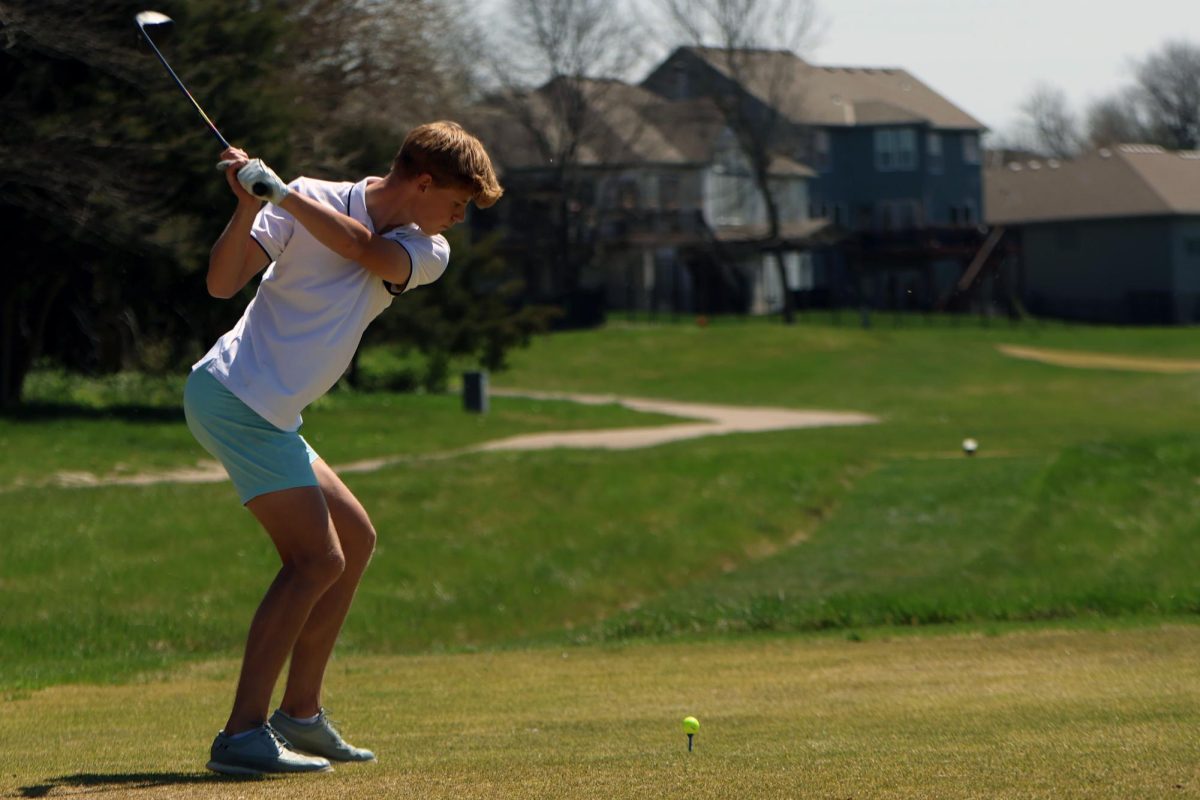 Swinging his golf club, freshmen Eli Platz, prepares to tee off. 