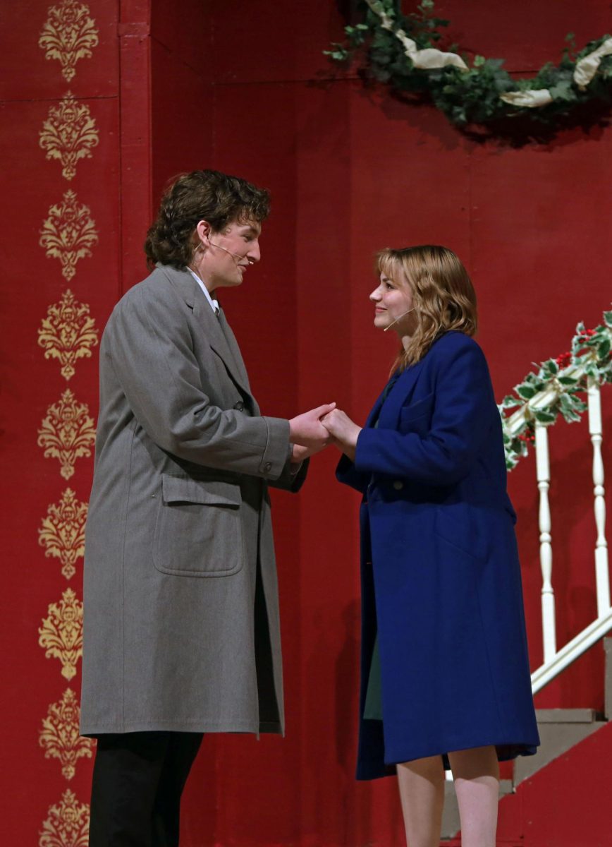 Smiling at each other, Maggie Cutler, played by senior Ryleigh McCall, and Bert Jefferson, played by junior Blake Gray, hold hands. 