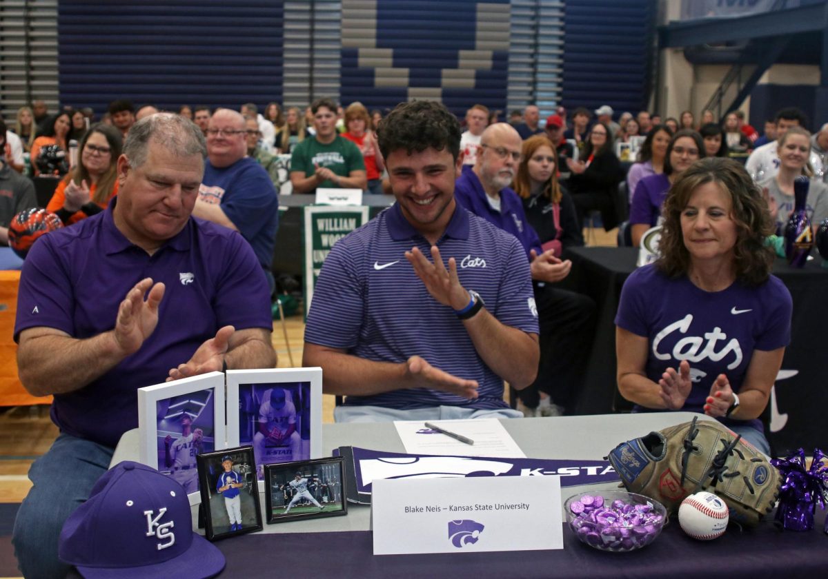 Clapping, signee senior Blake Neis prepares to sign at Kansas State University for baseball. 