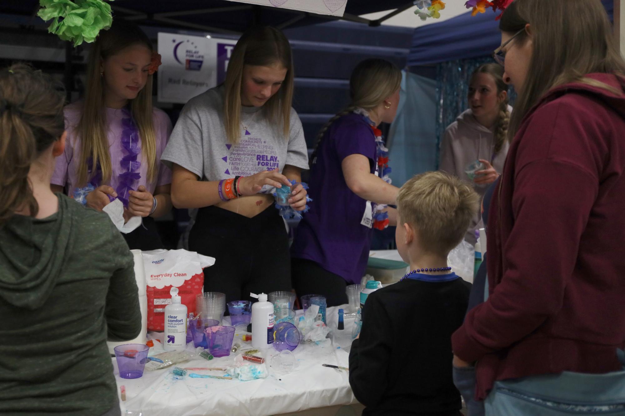 Preparing the booth, a Relay for Life volunteer packages the slime for one of the kids. 