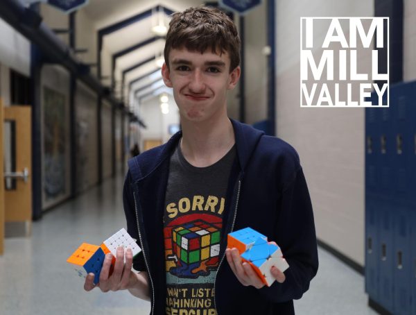 Smiling, junior Gabe Coleman holds up his rubix cubes. 
