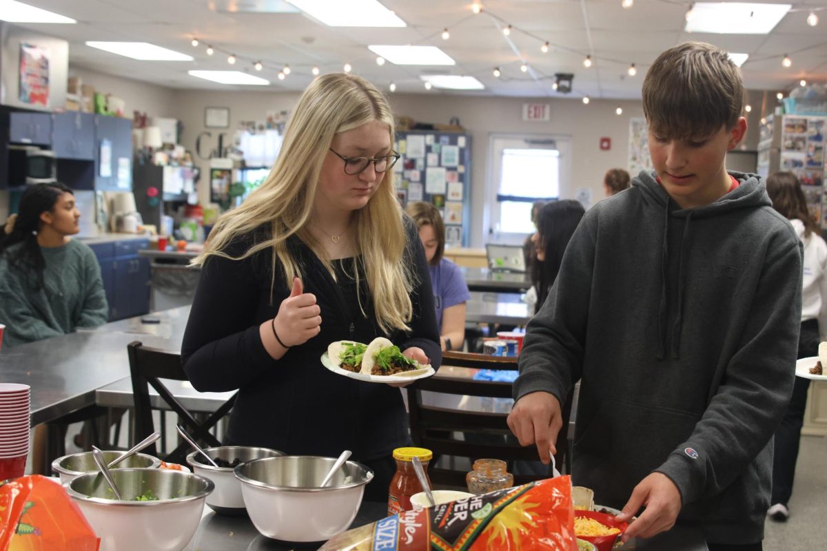 Enjoying the Spanish National Honor Society taco bar, junior Audrey Mulloy and sophomore Grant Kuchynka prepare their meal Wednesday April, 24.