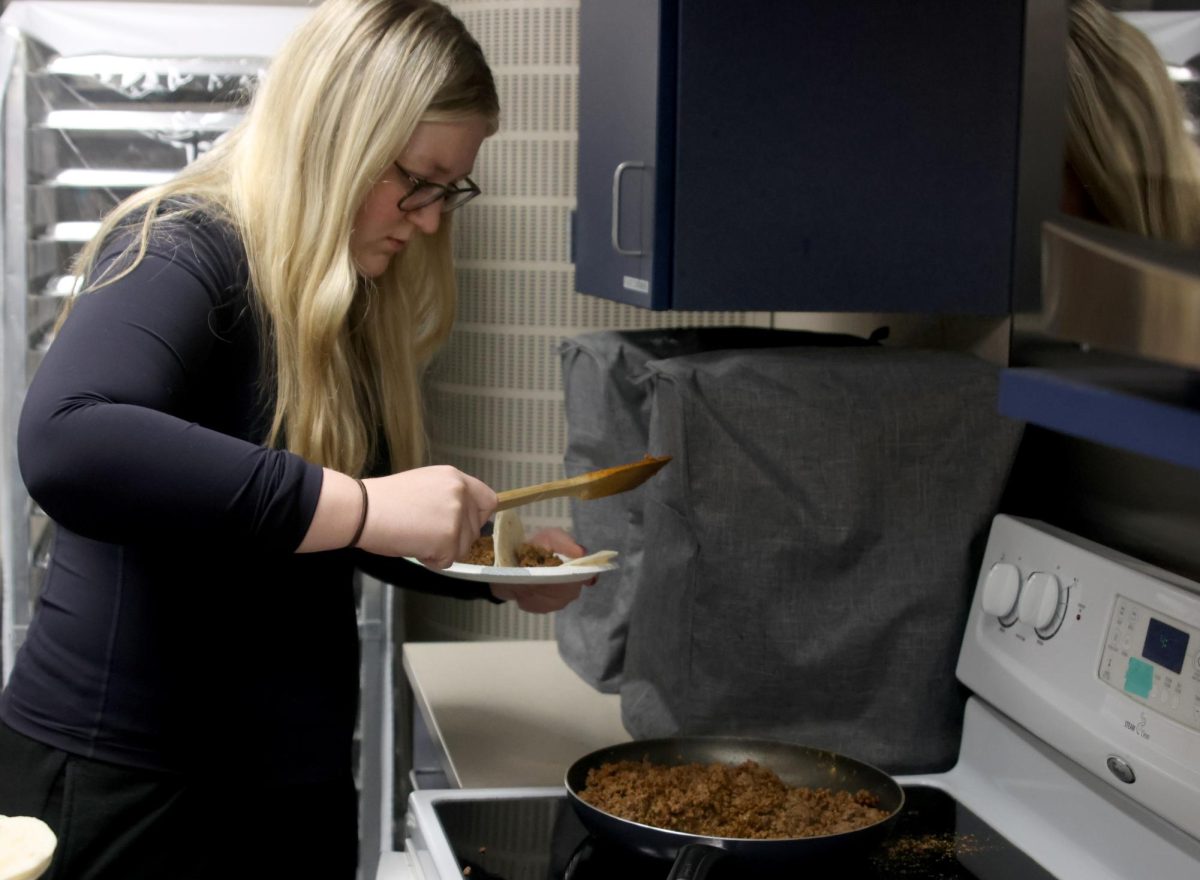 Carefully scooping the taco meat, Junior Audrey Mulloy assembles her dish.