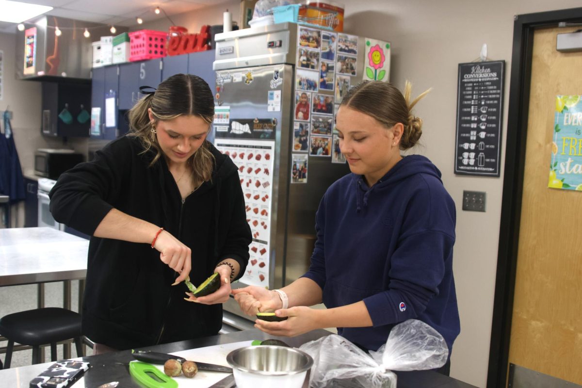 Seniors Bryn Simpson and Leah Dresvyannikov prepare the avocados for the taco bar.