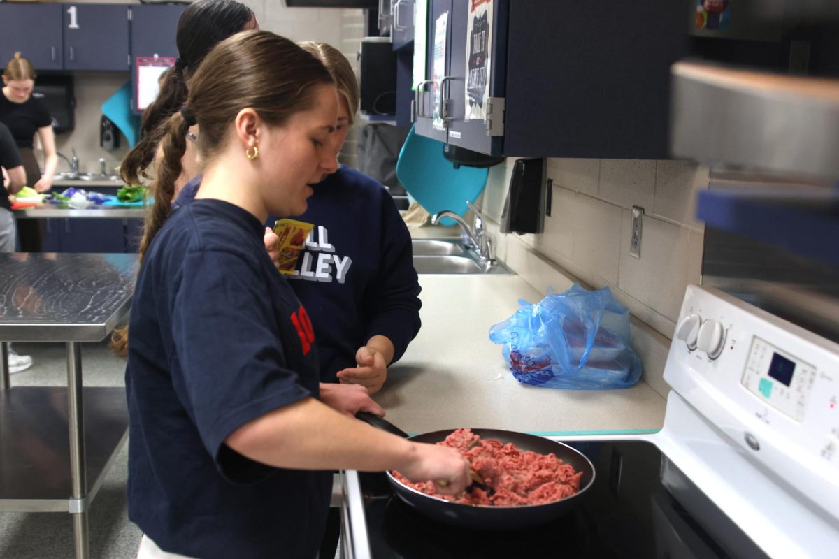 Senior Ellie Walker cooks the taco meat for her SNHS peers.
