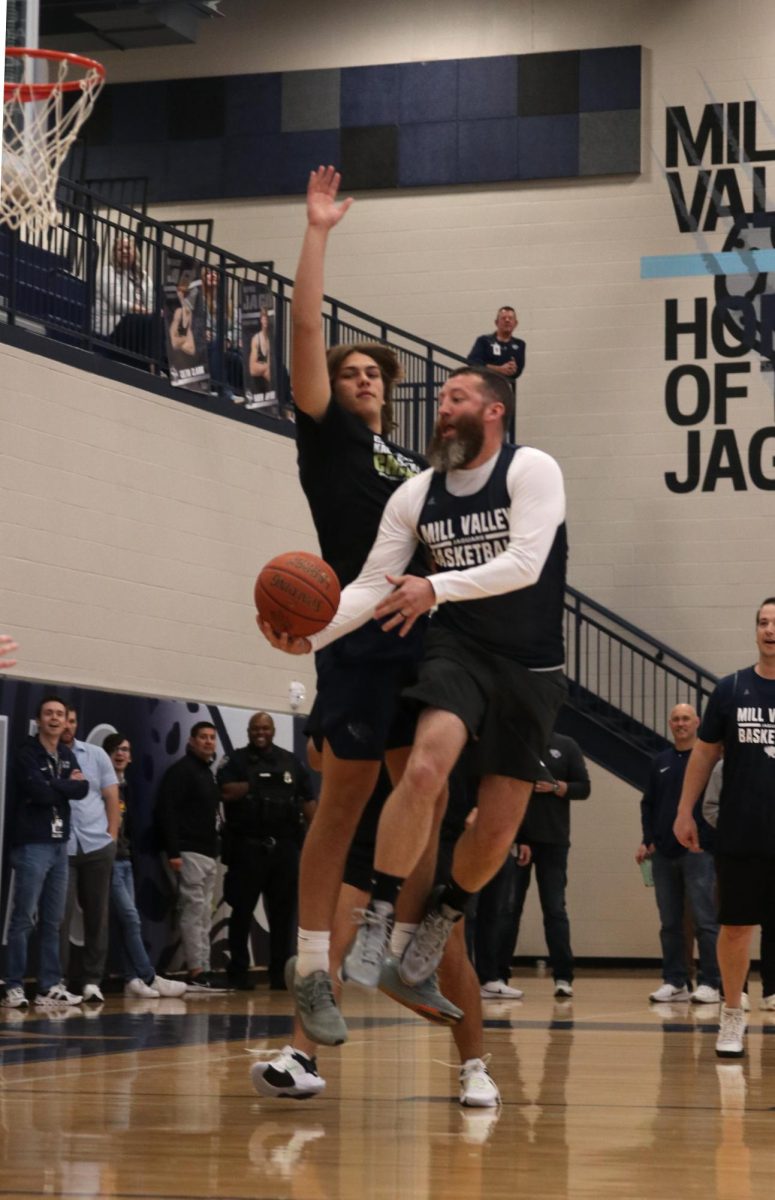 With an attempt to block athletic director Brent Bechard, senior Sully Suderman plays basketball at the prom assembly.