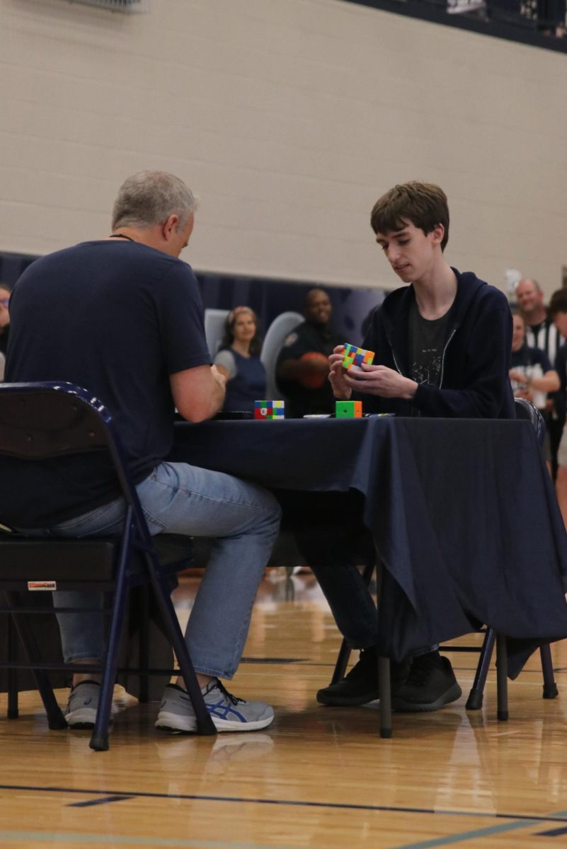 Junior Gabe Coleman competes in a rubix cube competition where he won against history teacher Jeff Wieland.