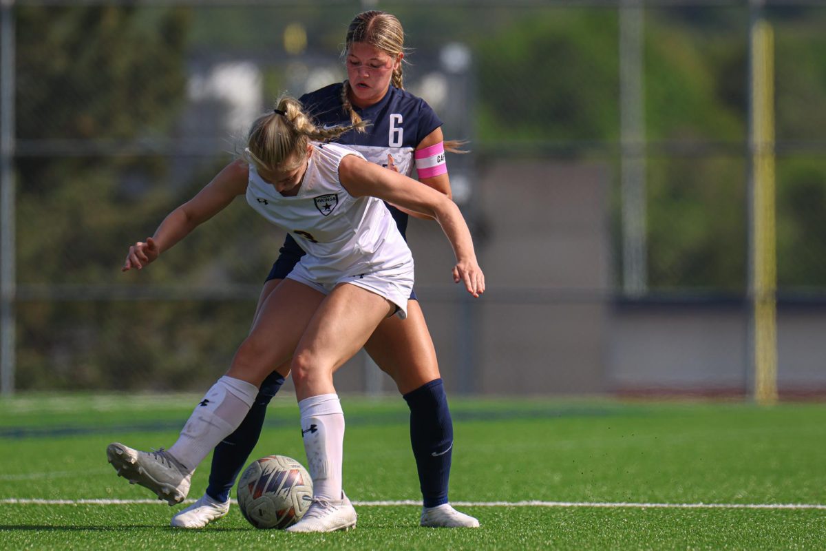 Looking down at the ball, senior Brooke Bellehumeur steals the ball from her opponent.