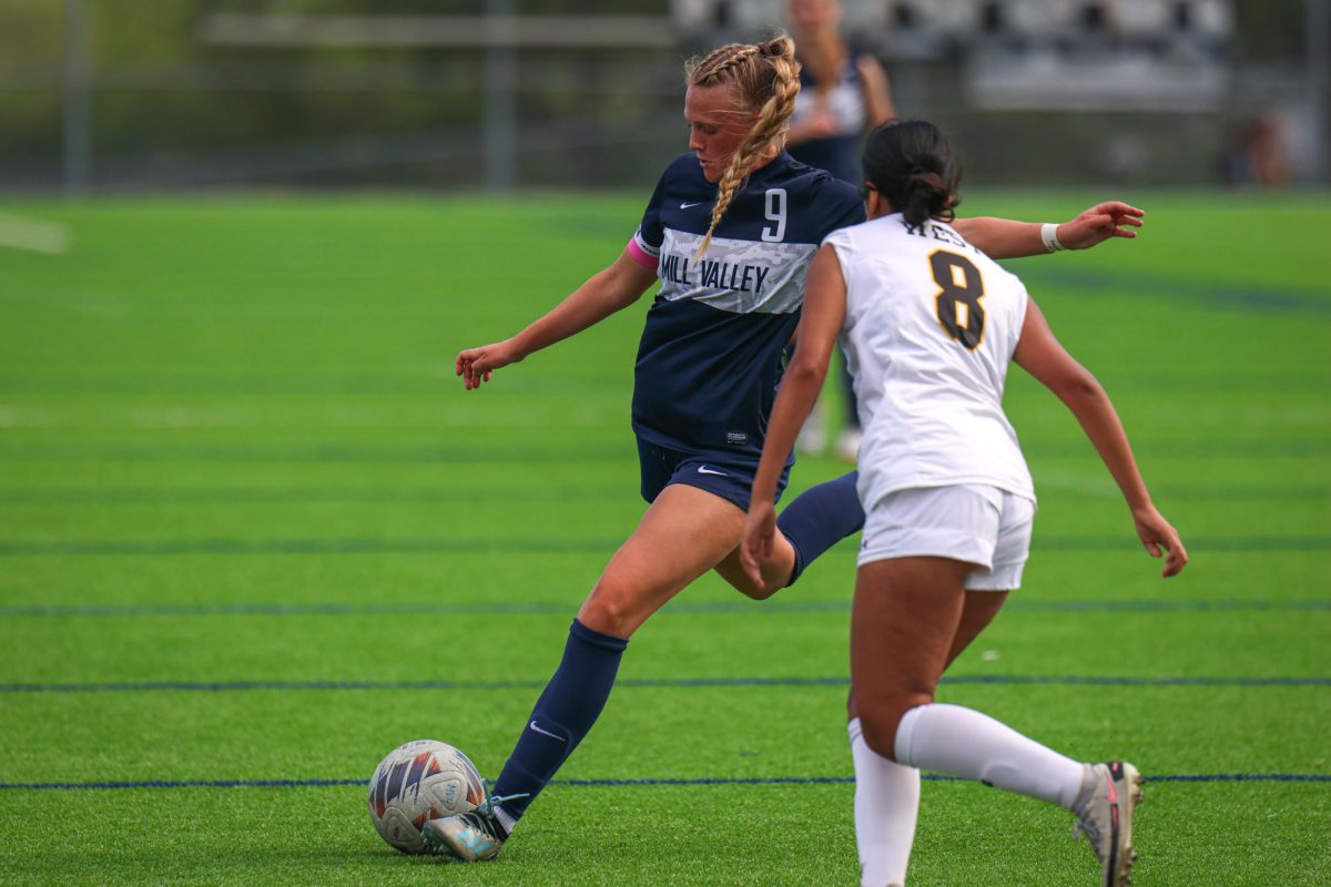 With her leg back, senior Julia Coacher takes a shot at the goal. 