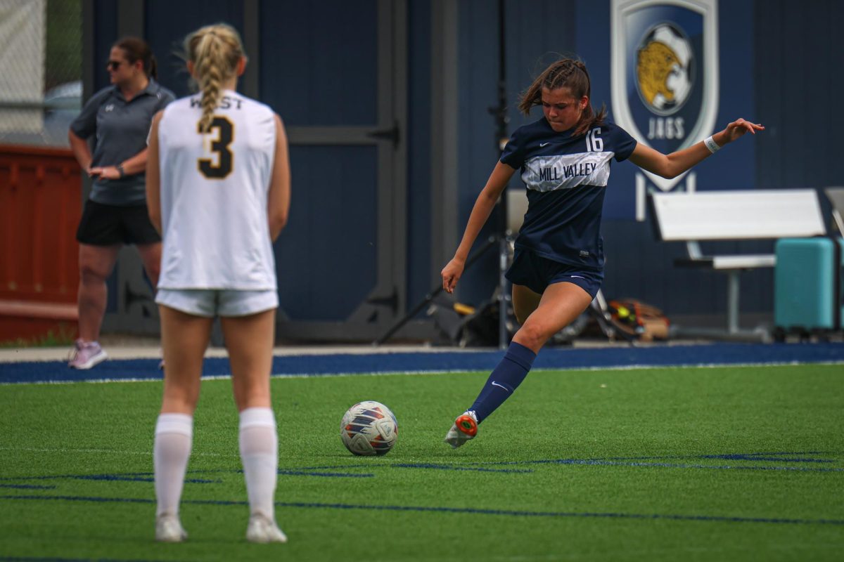 Preparing to kick the ball, freshman Alyssa Emo passes the ball down field. 