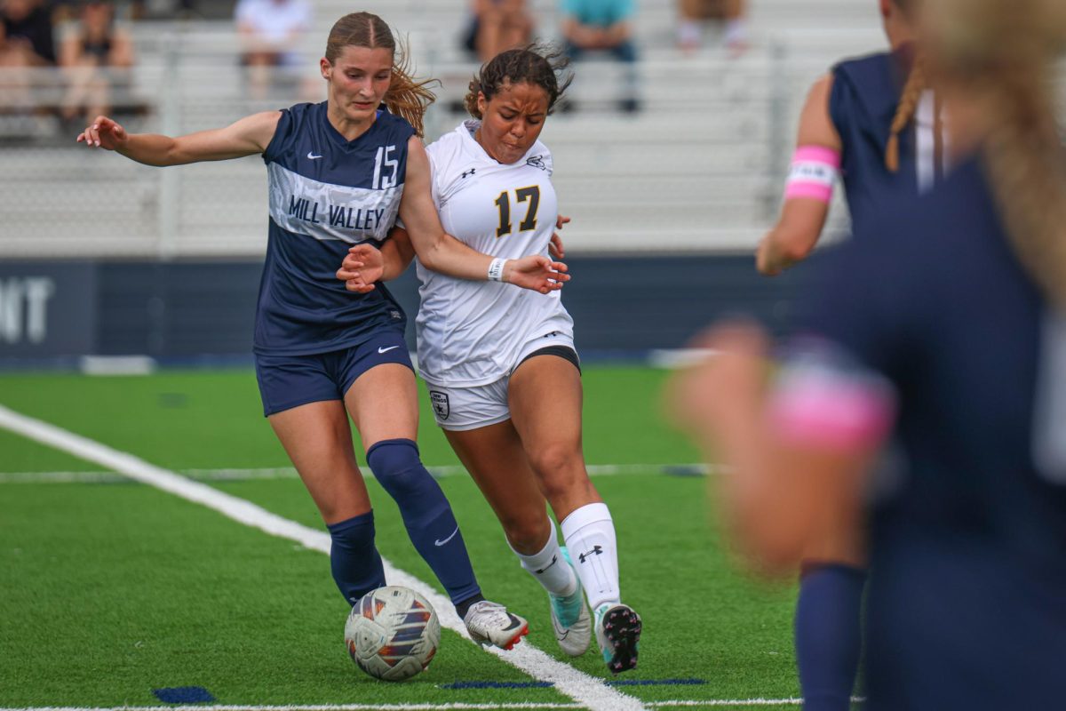 Pushing away the defender, junior Kate Martin controls the ball.