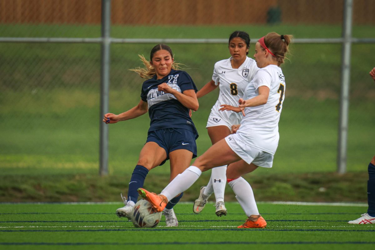 Making contact with the ball, freshman Paige Frost contests the defender. 