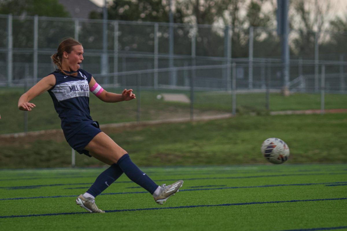 with her leg out stretched, senior Kate Ricker delivers a pass to her teammate. 