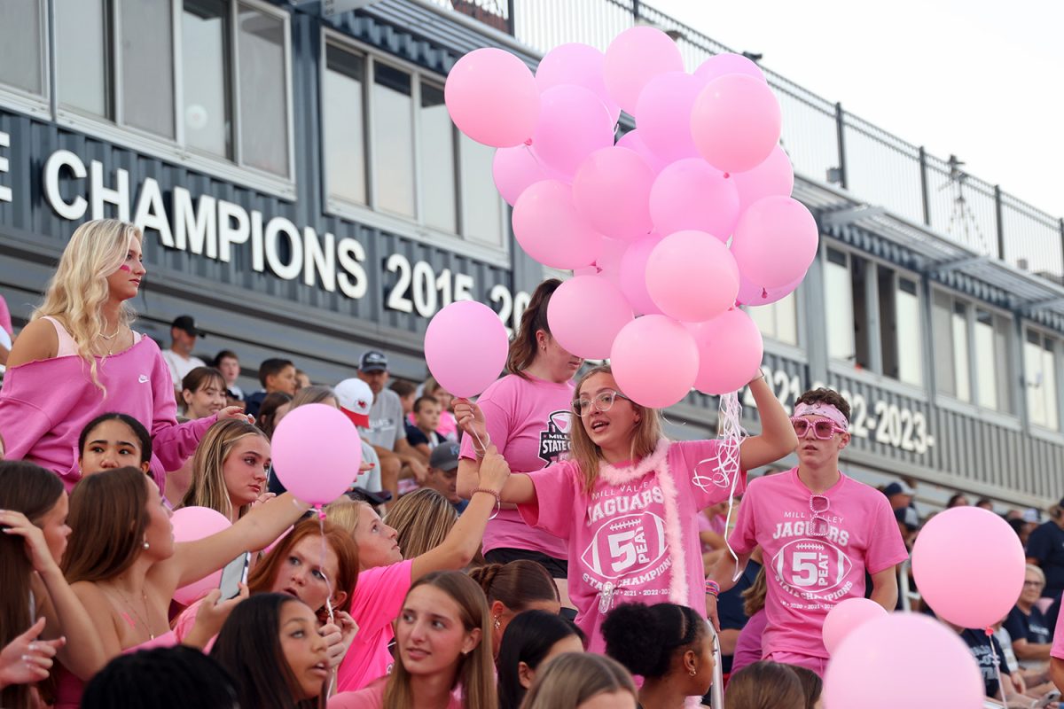 Handing out balloons, junior Madison Roberts explains when to release them.
