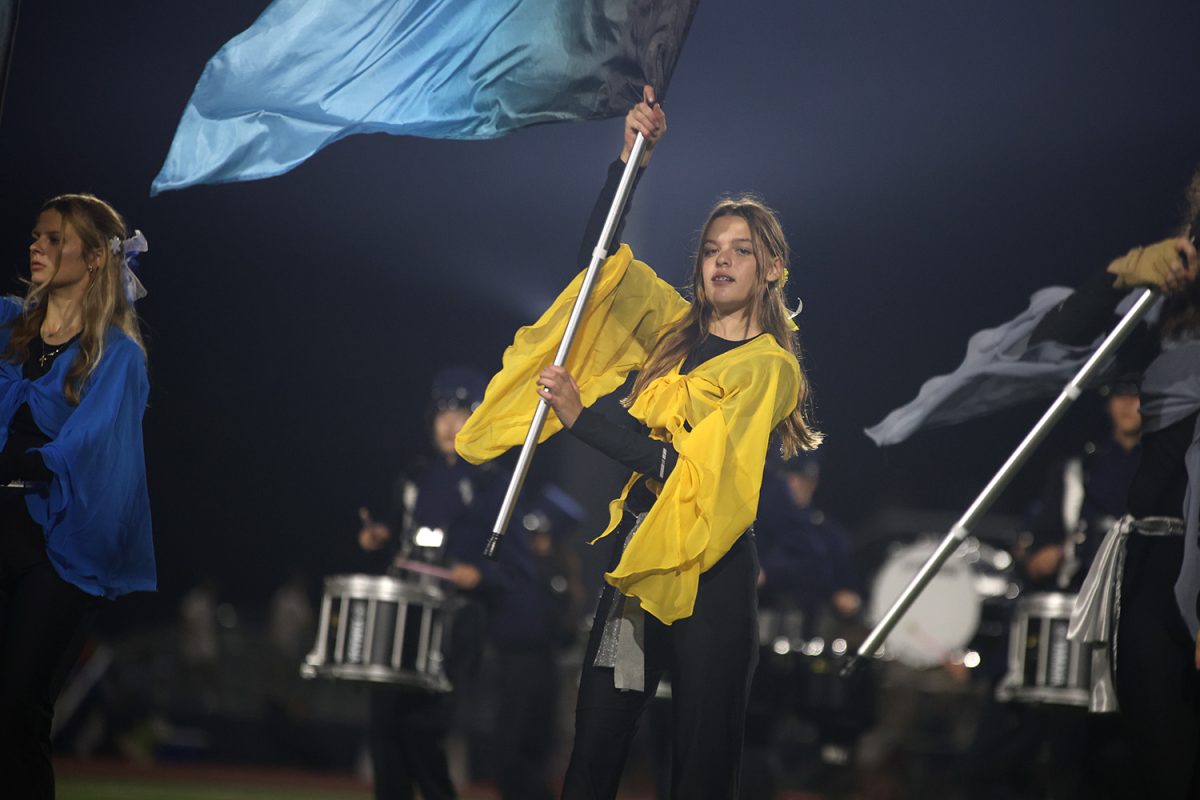 Focused, freshman Leah Schmidtmann waves her flag above her.