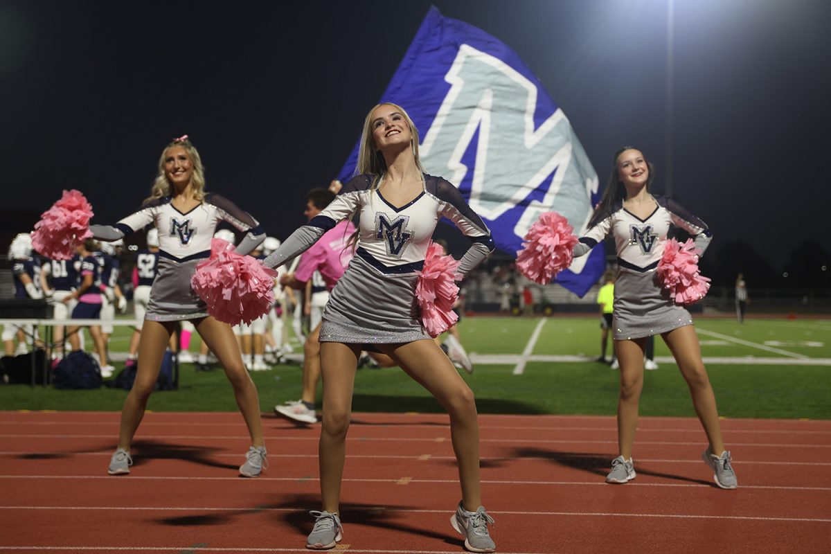 With a smile, junior Bailey Bret dances while the MVHS flags run behind her. 