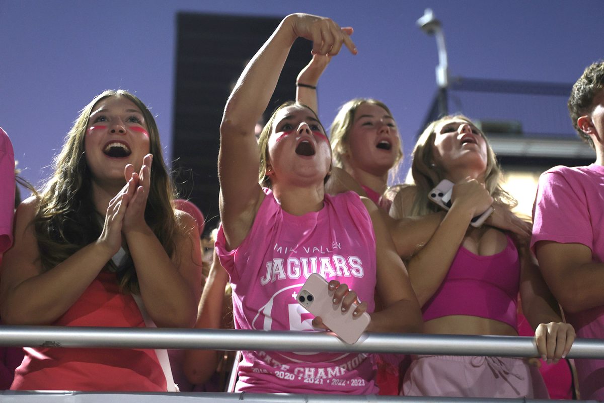 Hand in the air, senior Lauren Welch cheers along to the party chant.