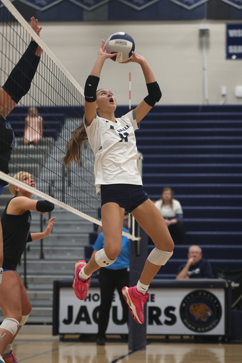 In mid-air, senior junior Ella Florez reaches for the ball to set up her teammate Tuesday, Oct 1. 