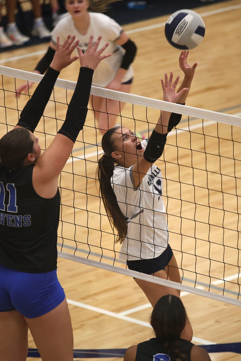 Calling to her teammate, junior Ella Florez sets the ball Tuesday, Oct 1.