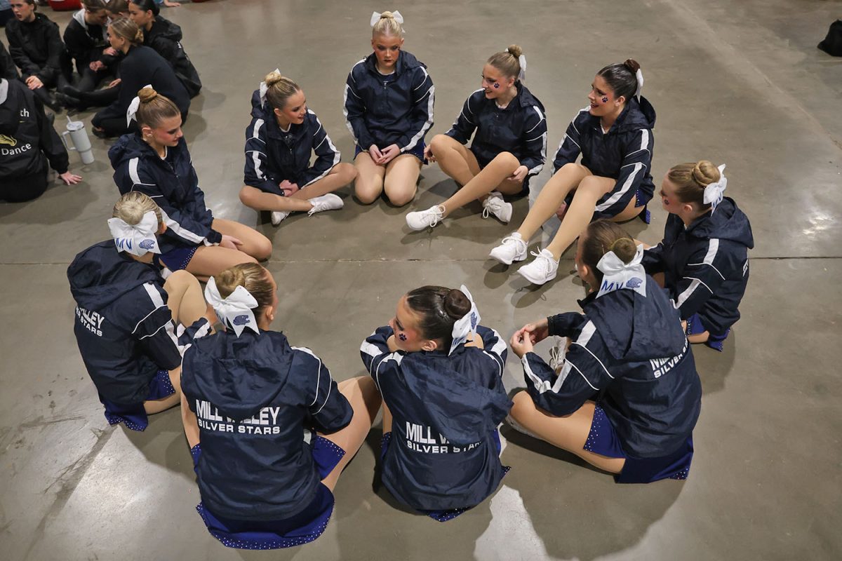 Sitting in a circle, the team waits for the finalists to be announced.