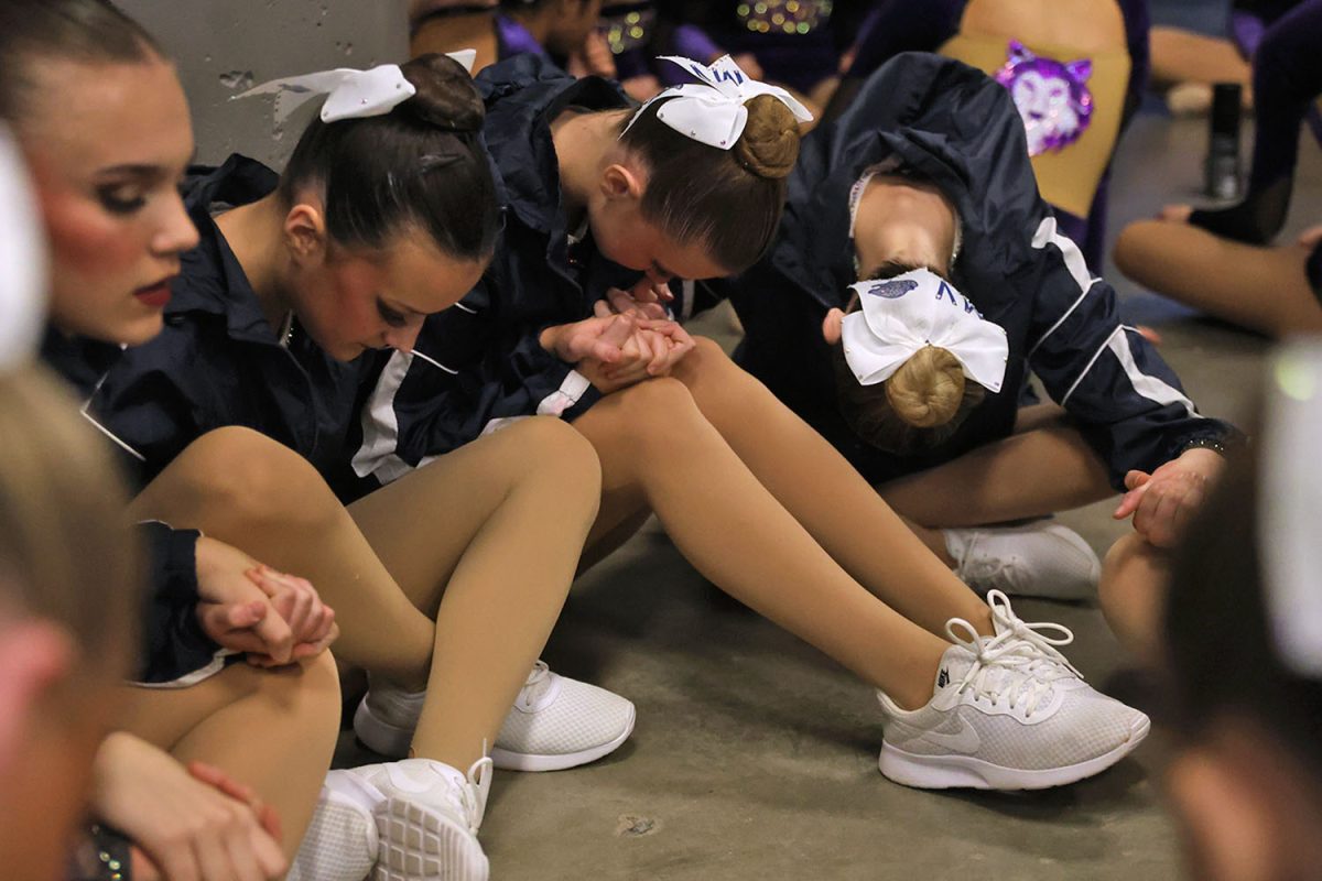 Heads down, the dancers hold hands and listen closely for the 6A announcements. 