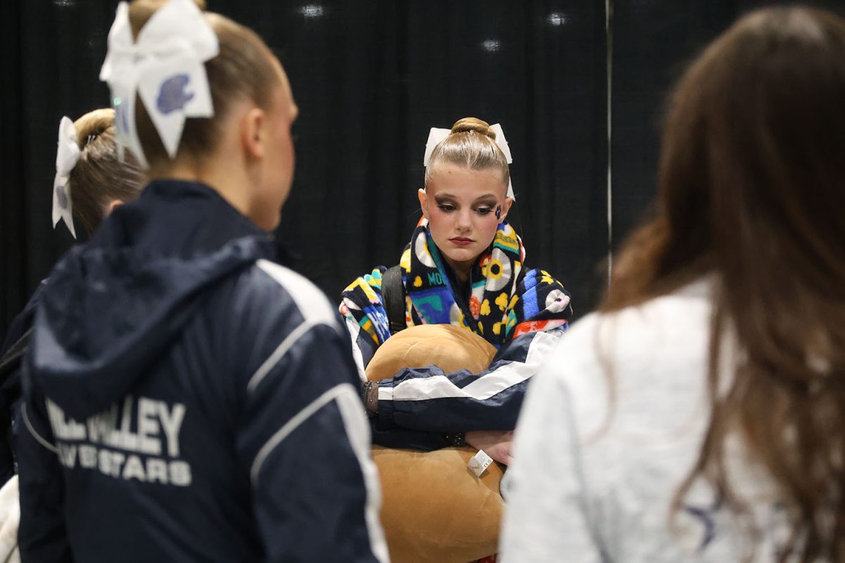 Holding a pillow, junior Ella Jones listens to her coaches closing remarks.