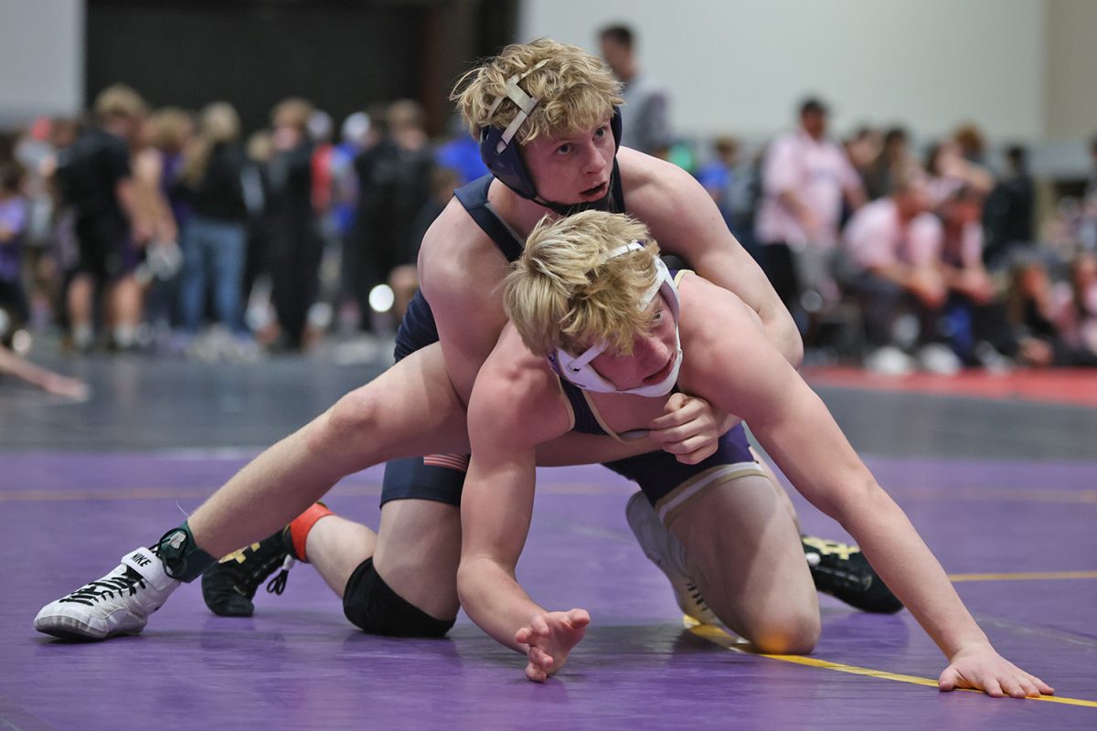 Looking up, senior Colton Bendure checks the scoreboard after scoring a takedown.