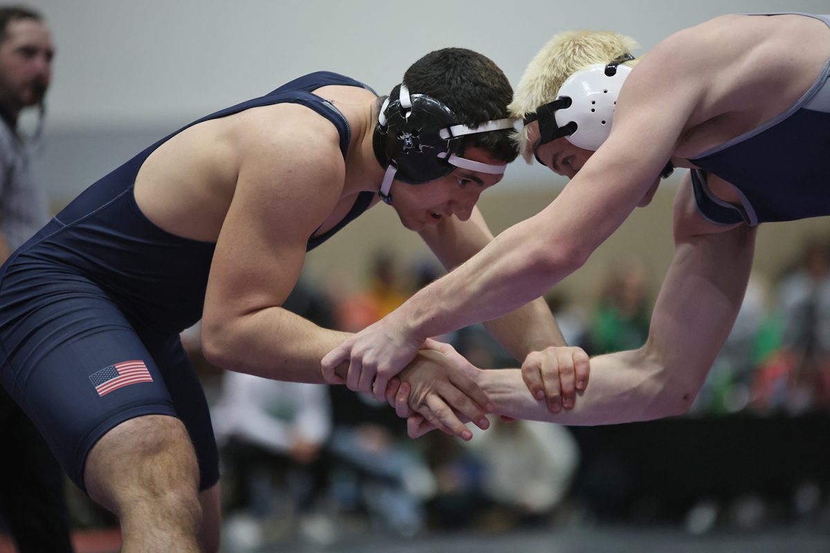 Hands locked, sophomore Ryder Farley wrestles with his opponent at the Stampede meet.
