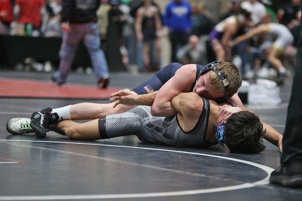 Pulling back his opponents arm, junior Jeredy Nilges works to pin the other wrestler.