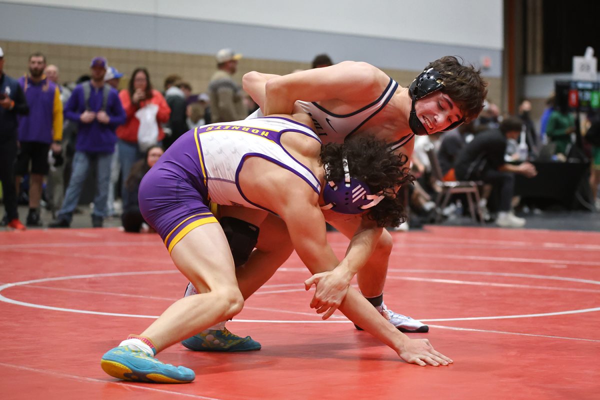 Reaching down, junior Ethan Leon works to put his opponent to his back.