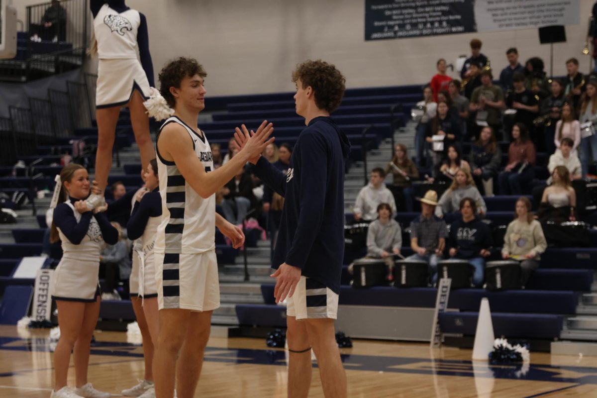 After being announced, junior Reece Riedel performs his pregame handshake with sophomore Hayes Henderson.
