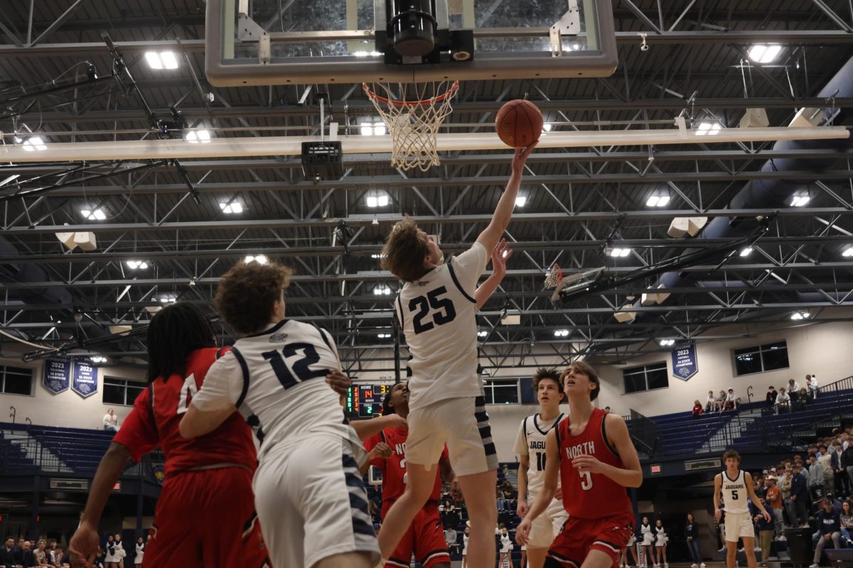 Extending his arm, senior Carter Kaifes shoots a reverse layup. 
