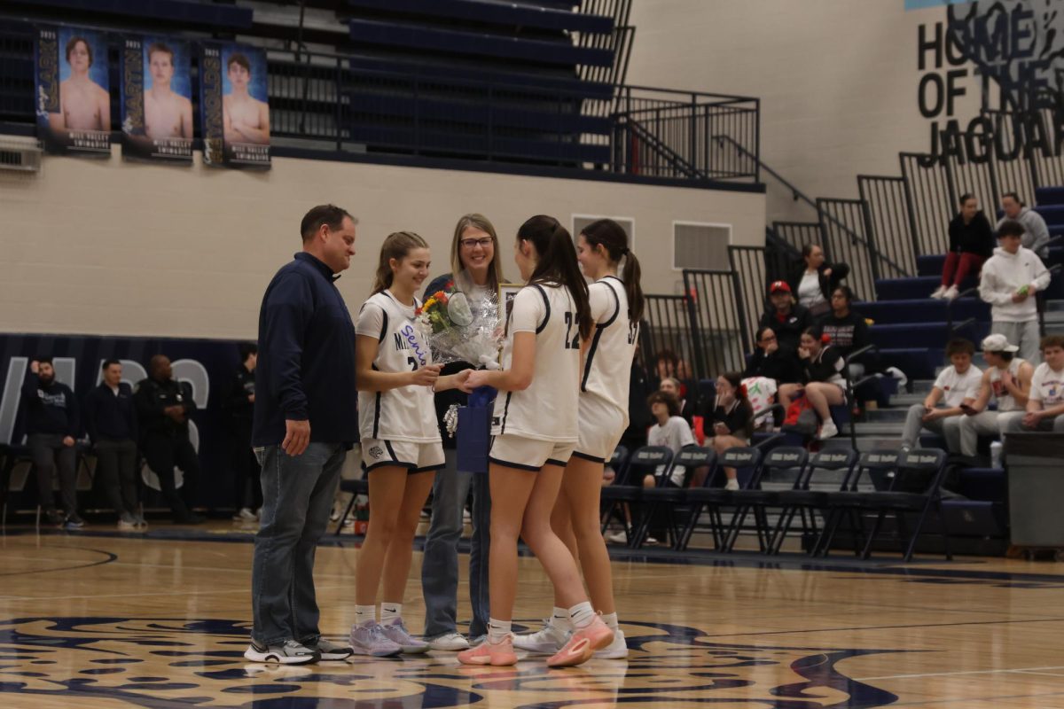 Senior Averie Landon receives flowers and gifts from her teammates during senior night. 
