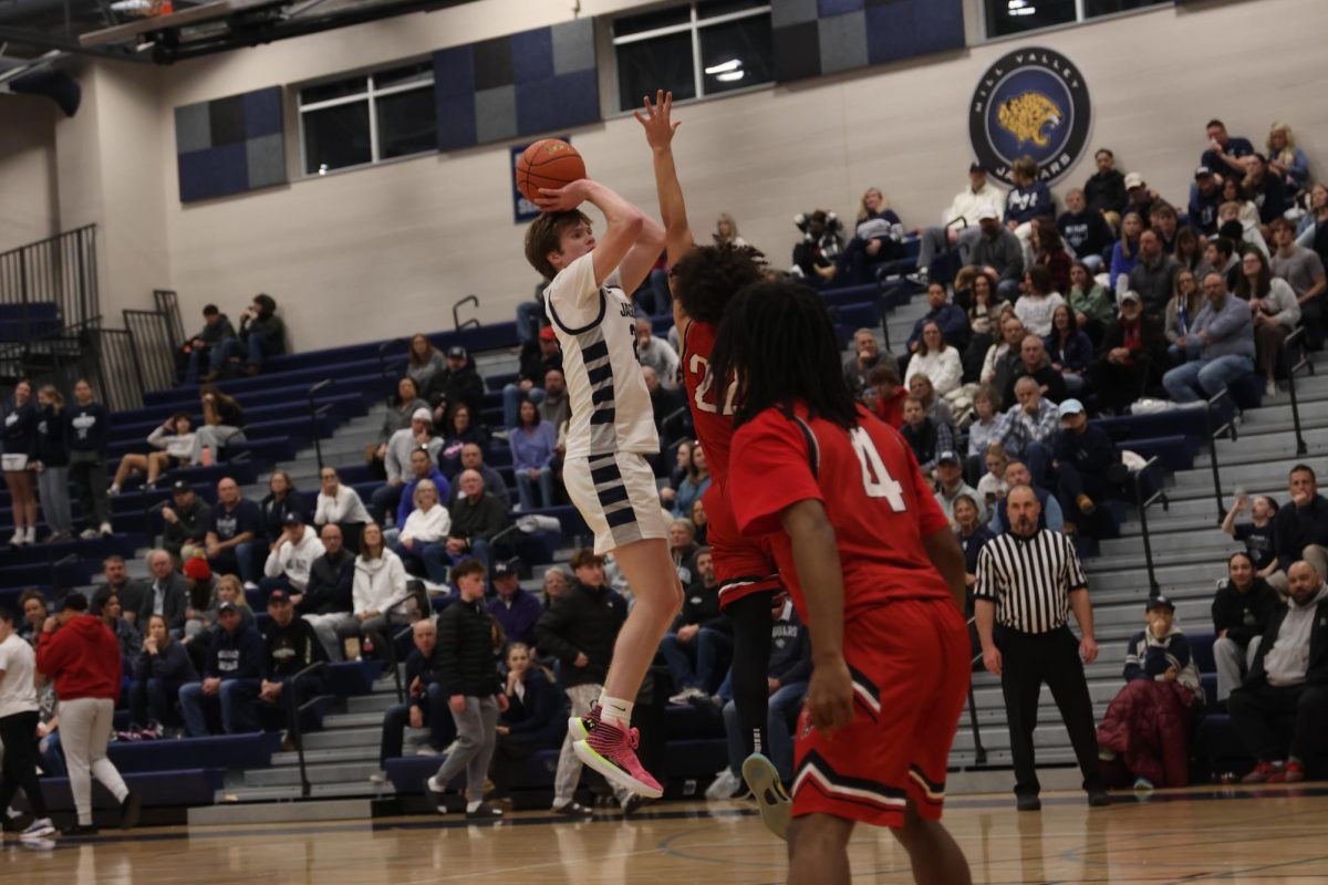 Focusing on the net, senior Carter Kaifes takes a jump shot.
