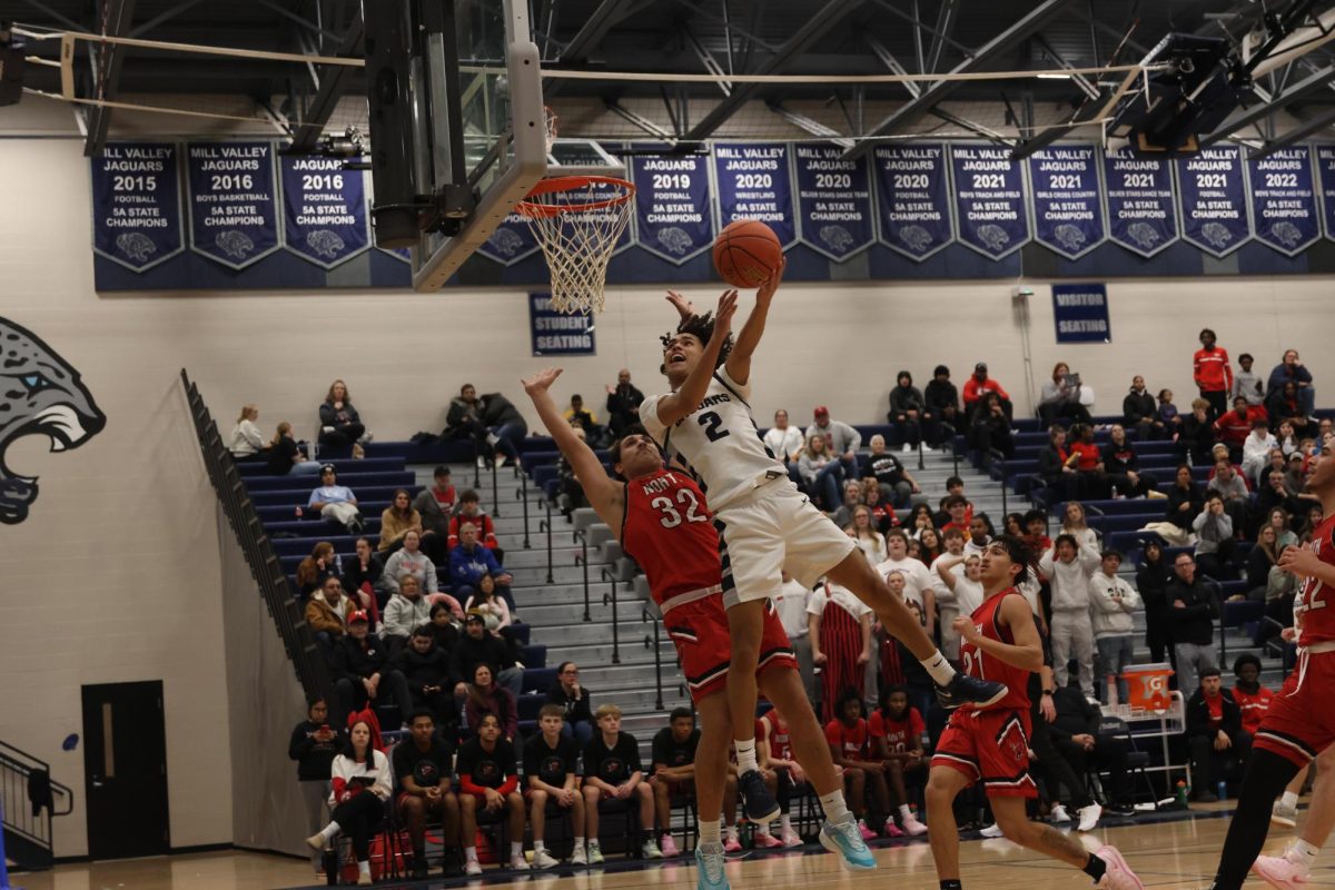 In mid-air, junior JaKhai Carter looks to dunk the ball.
