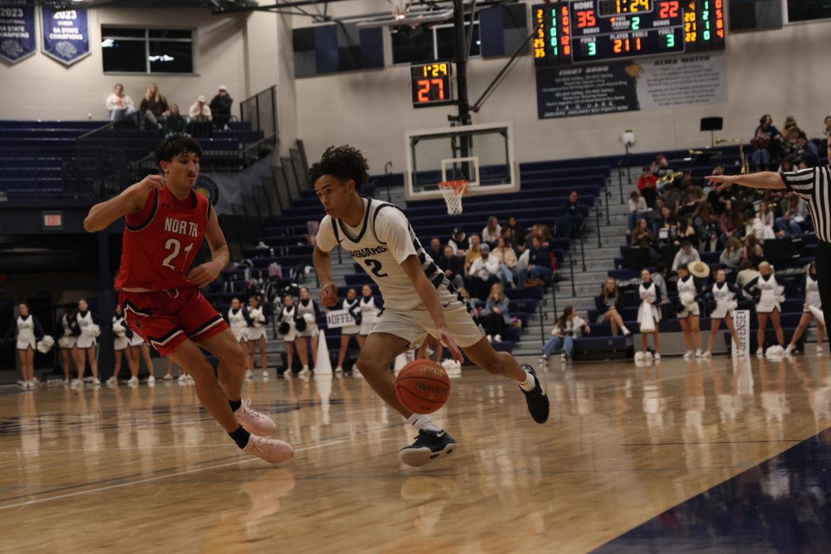 Beating a Shawnee Mission North opponent, junior JaKhai Carter drives toward the basket.  
