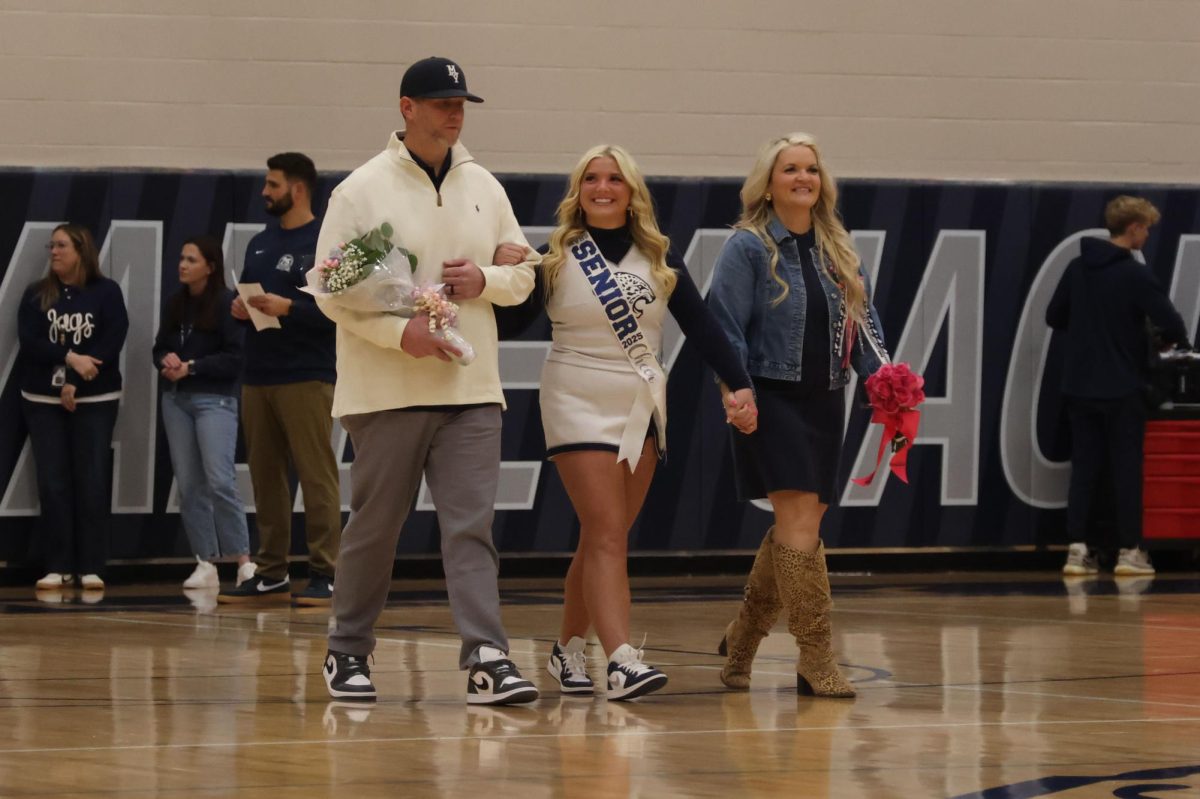 Smiling toward the crowd, senior Maddie Dibble is recognized on senior night.