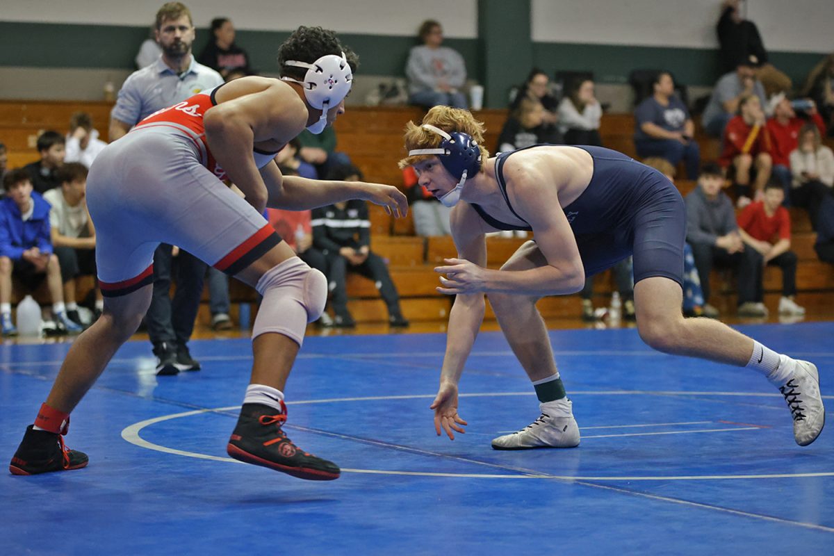 Low to the ground, sophomore William Gadwood squares off to start his match.