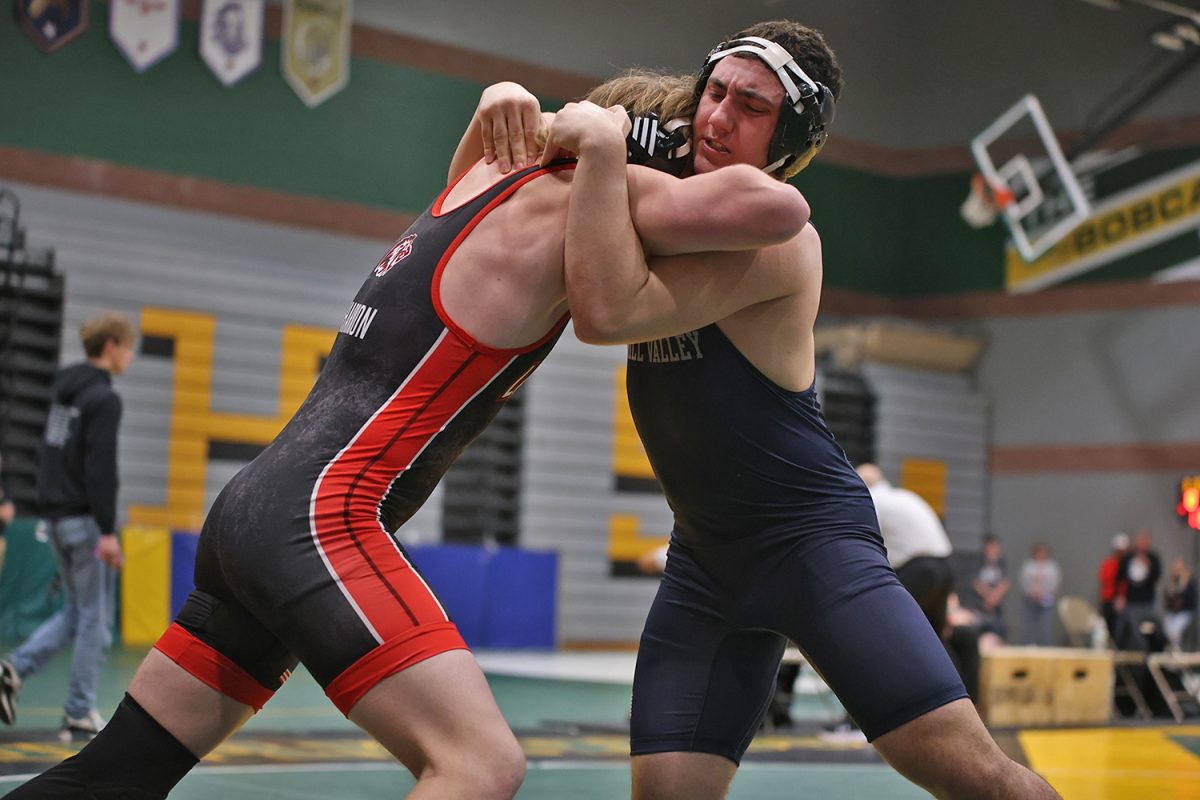 Arms interlocked with his opponent, sophomore Ryder Farley tries to bring the other wrestler to the mat. 