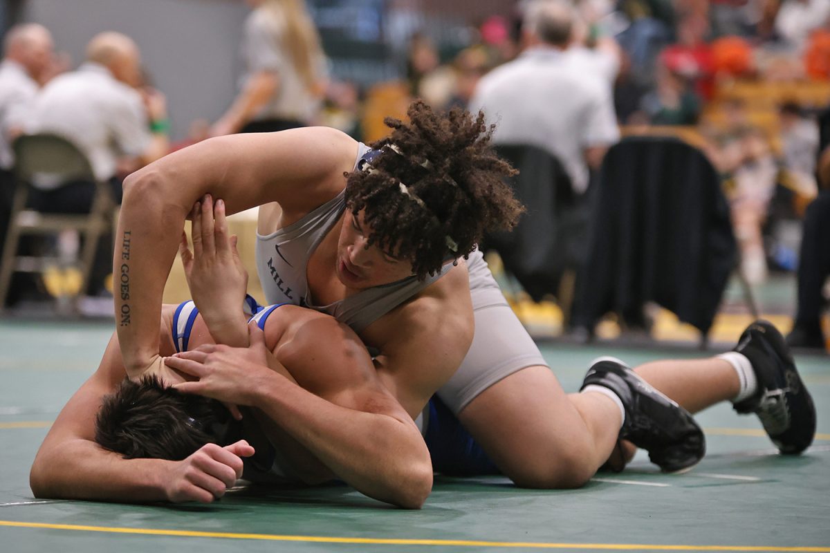 Pressing down the wrestlers head, junior MJ Wash locks his arms together. 