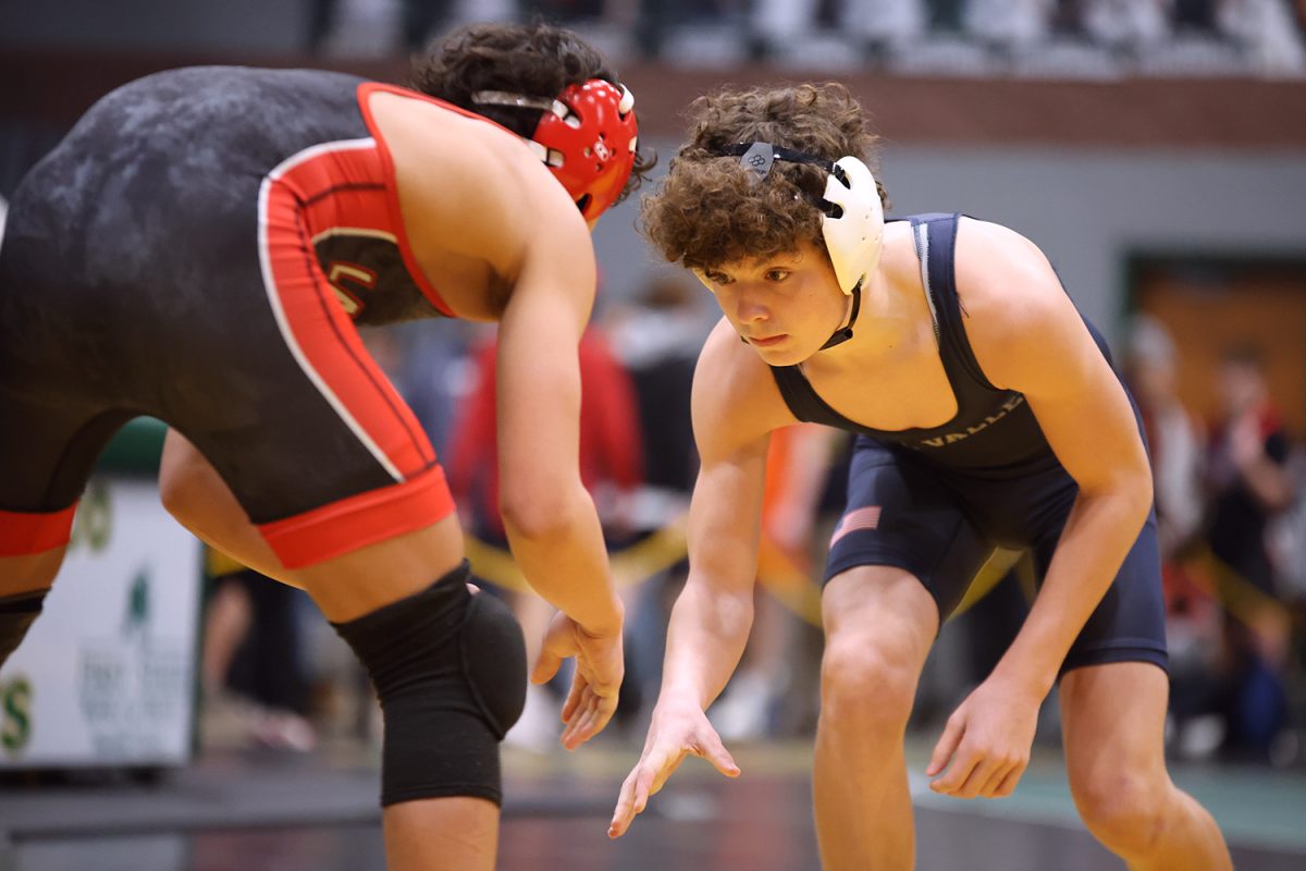 Focused, freshman Garrett Hansen faces off against another wrestler. 