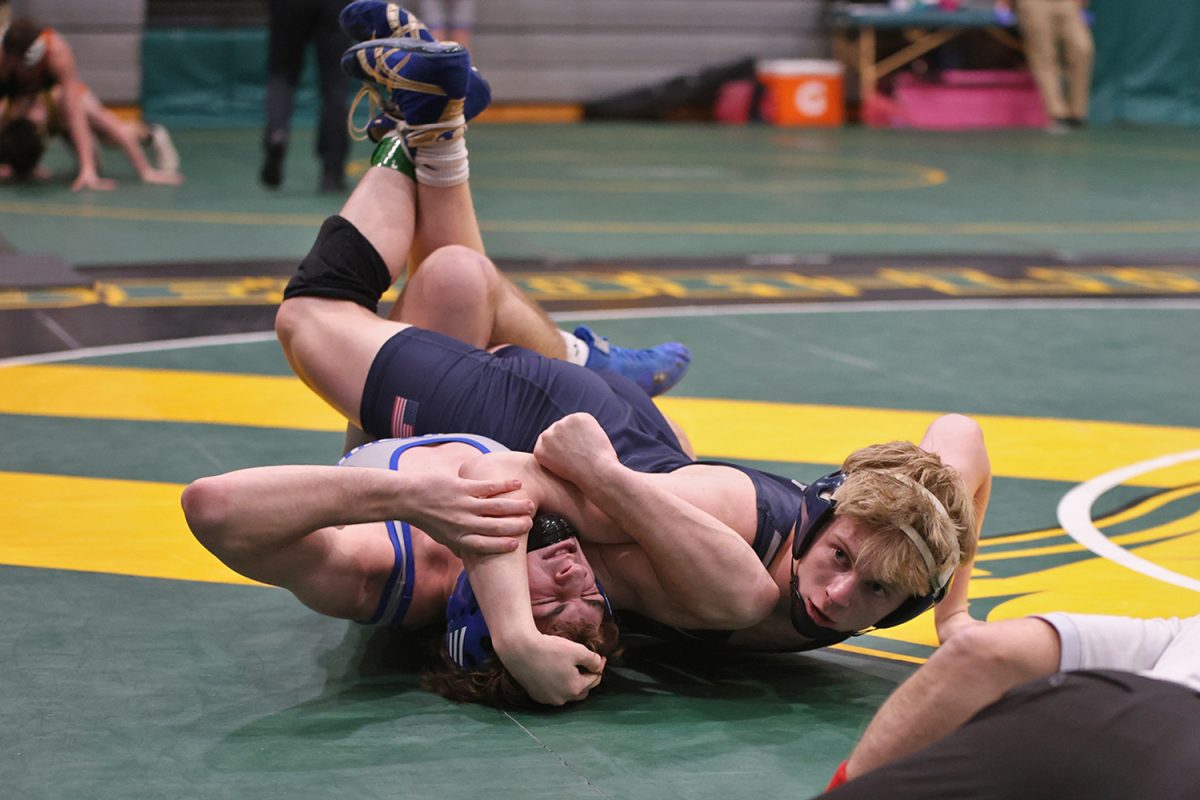 With a glance at his coach, senior Colton Bendure presses his opponents head down. 
