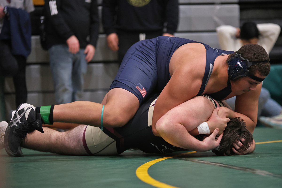Hands interlocked, junior Lamarcus Barber works to roll his opponent to his back. 