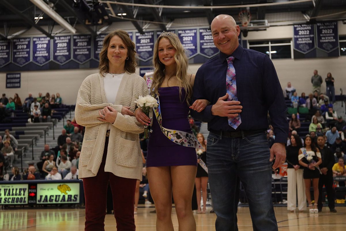 Senior Josie Benson smiles for the camera alongside her parents.