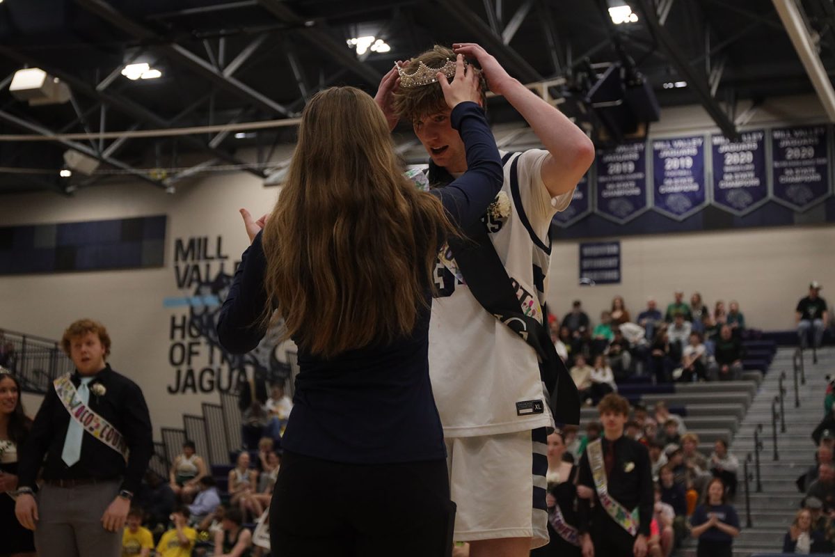 Adjusting his crown, senior Carter Kaifes is voted as Winter Homecoming King king at halftime of the boy's basketball game.